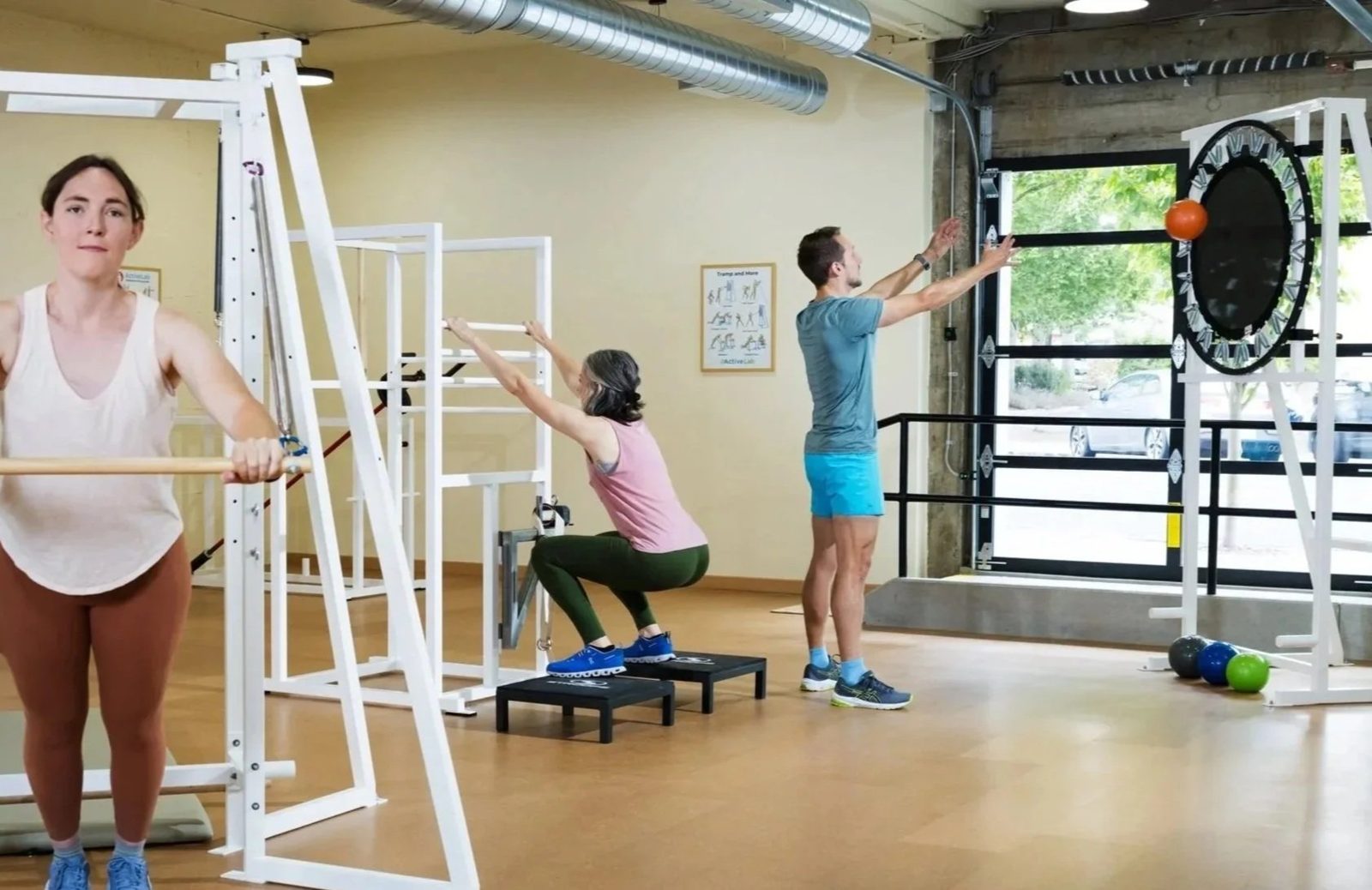 Two women and a man in athletic attire performing various pilates, strength, mobility, and pre-therapy exercises at ActiveLab gym in Vancouver, WA